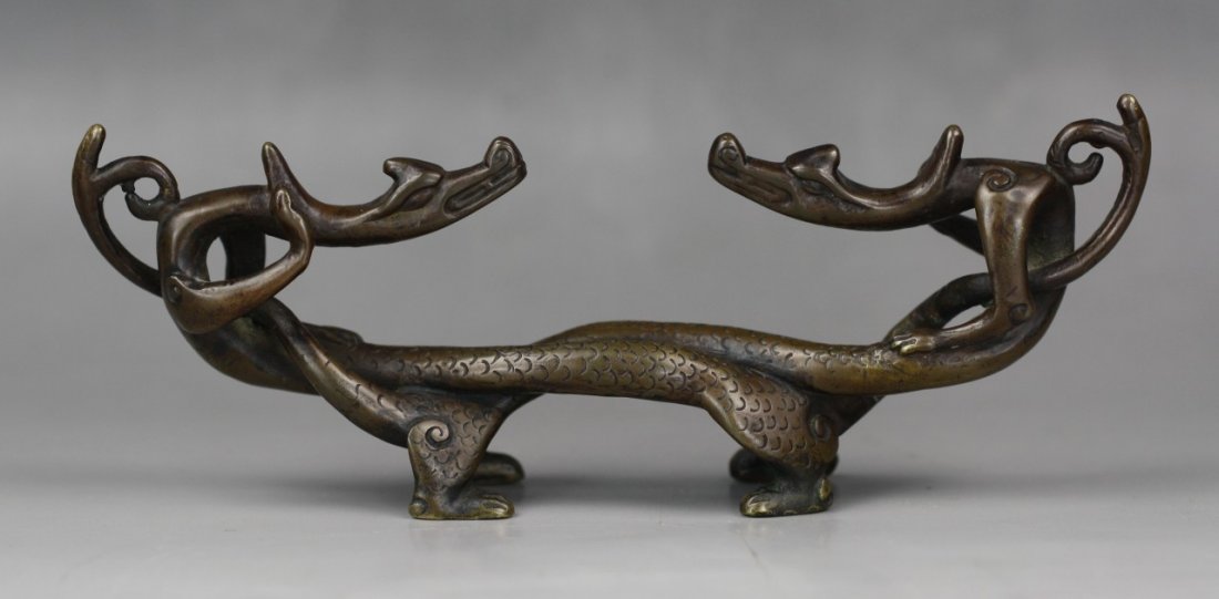 A Chinese Carved Antique Bronze Brushrest: A Chinese Carved Antique Bronze Brushrest: modelled as two Chi-dragon twisting together with face to face, Size: L: 6-5/8"