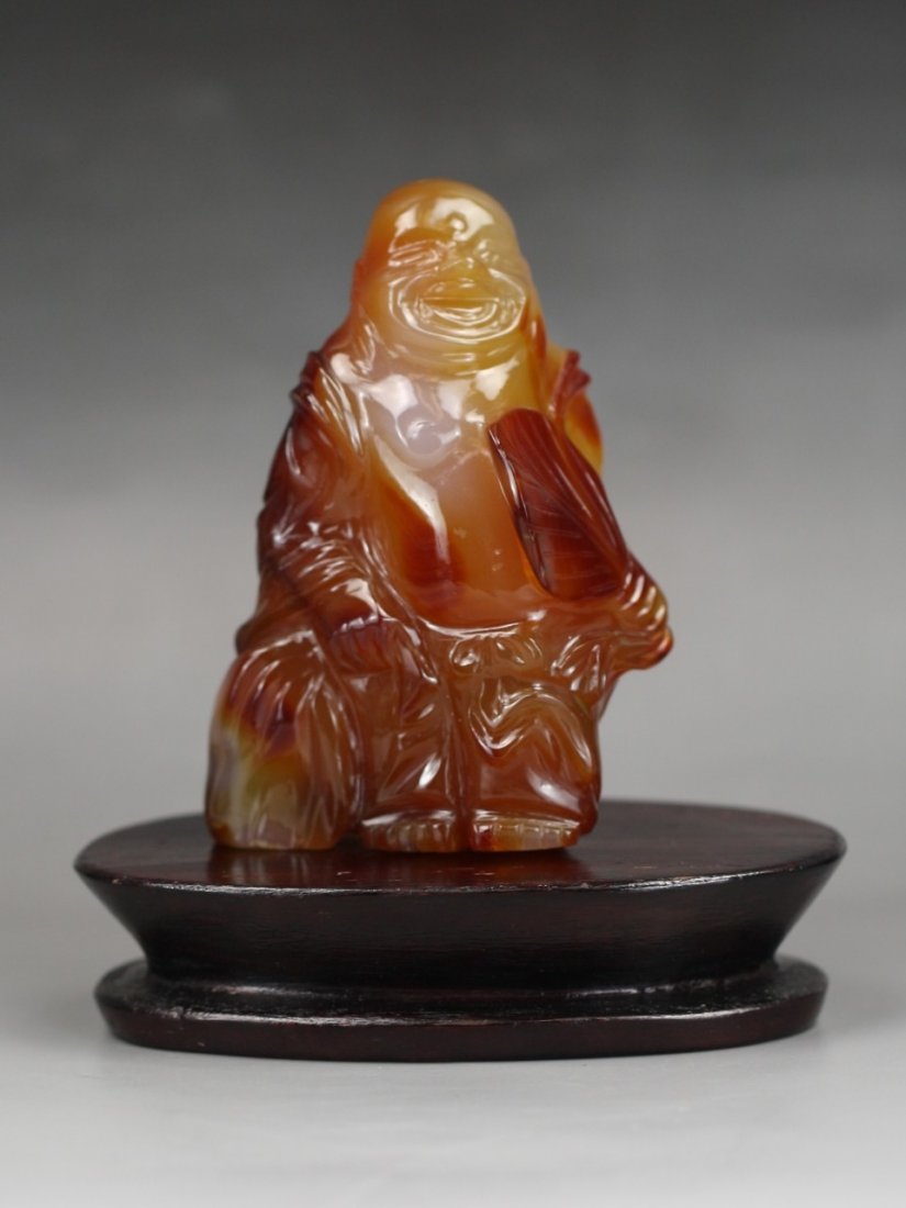 A Fine Chinese Carved Carnelian Agate Buddha: A Fine Chinese Carved Carnelian Agate Buddha: on matching wood stand; Size: H: 3-1/2"