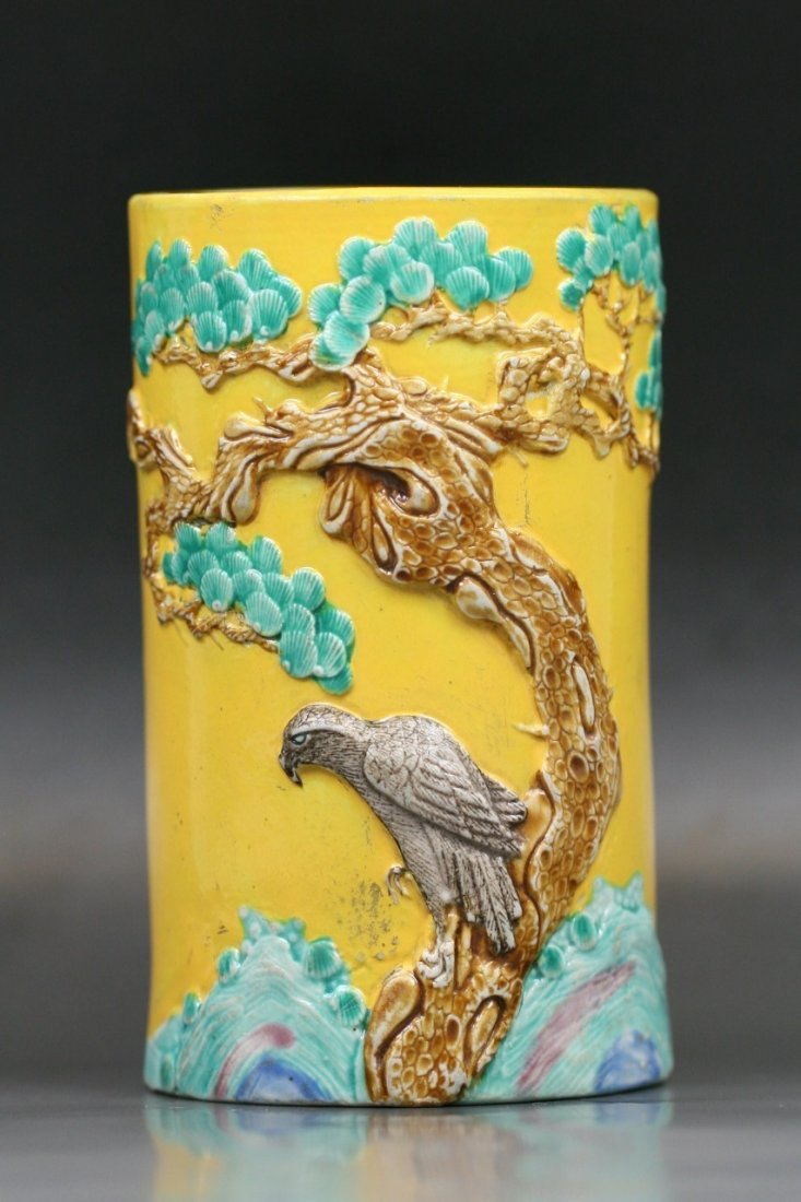 A Chinese Carved Porcelain Brush Pot: A Chinese Wang Bingrong-Inscribed Carved Porcelain Brush Pot: delicately molded in relief as an eagle perched on a pine tree issuing from rockwork, all reserved on a bright yellow-ground, the four cha