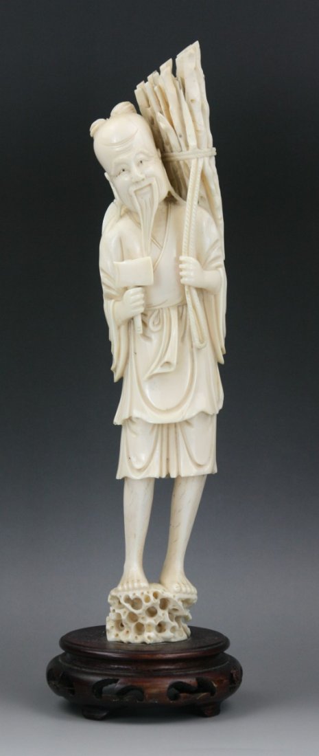 A Chinese Carved Ivory Farmer: A Chinese Carved Ivory Farmer: finely carved as a smiling farmer standing on rock carrying a bundle of branches on his back while holding an axe in his right hand; Size: H: 12"