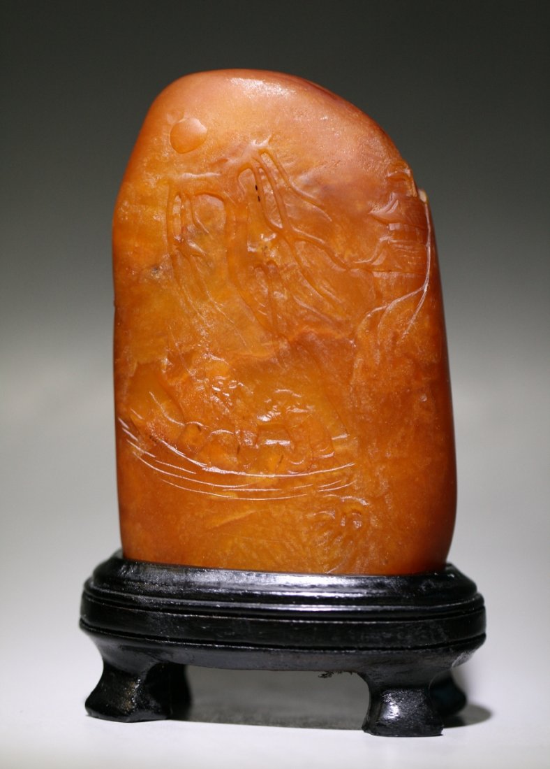 A Tianhuang-Like Stone Seal: A Tianhuang-Like Stone Seal: of rounded square pebble form, finely carved in low relief with a sage seated in a boat, the reverse with a plantain tree, the stone of ochre tone, with custom wood stand,