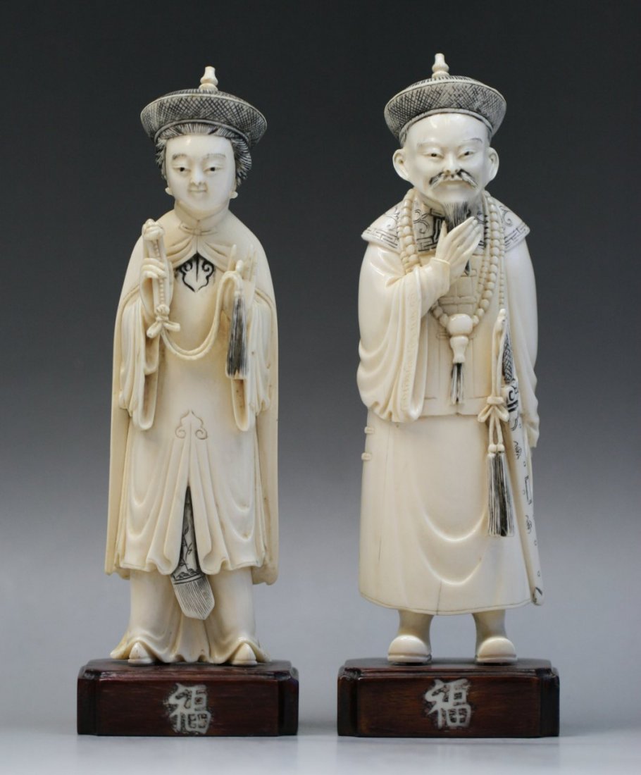 Chinese Carved Ivory Couple Of Officials: Chinese Carved Ivory Couple Of Officials: finely polished and carved as two male and female officials standing in long and flowing robes, both on wood stands with 'Fu' Characters, of Minguo Period; Si