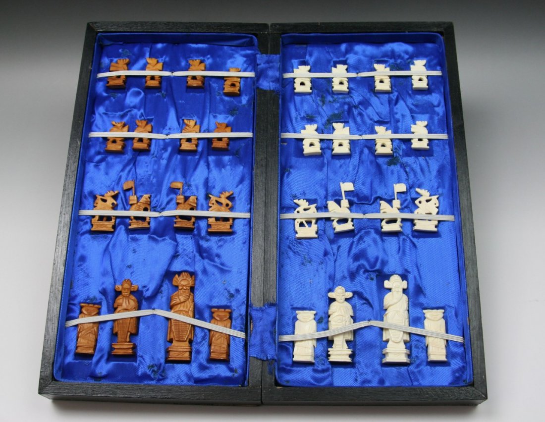 A Complete Set Of Chinese Carved Ivory Chess: A Complete Set Of Chinese Carved Ivory Chess: The opposing sides of white ivory and sienna dyed ivory are all solid carved pieces all raised on plinths, very good condition, all pieces present, in woo