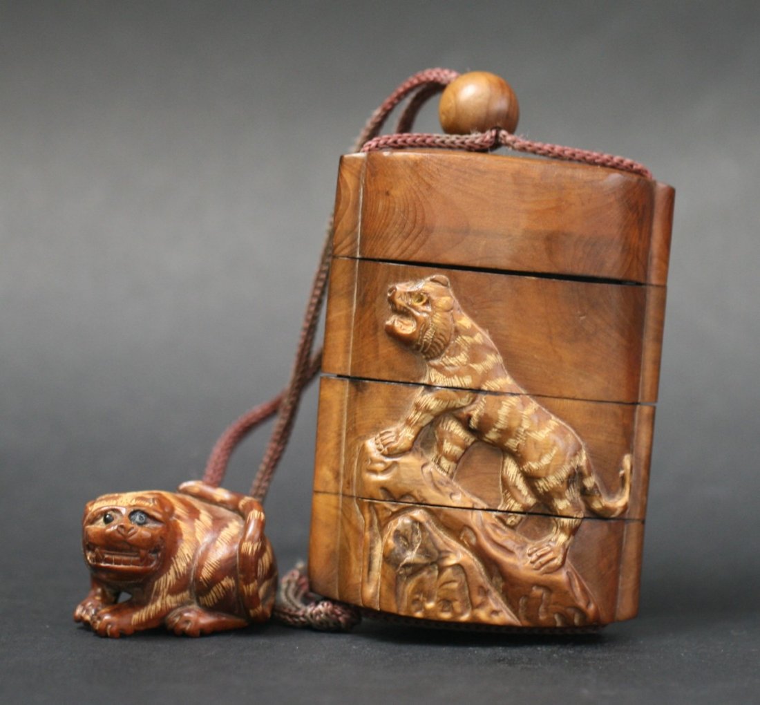 A Fine Japanese Antique Wood Inro Suite: A Fine Japanese Antique Wood Inro Suite: with tiger in relief design, inlaid eyes, with ojime bead and Shishi netsuke, signed on the base; Size: H: 3-1/4"