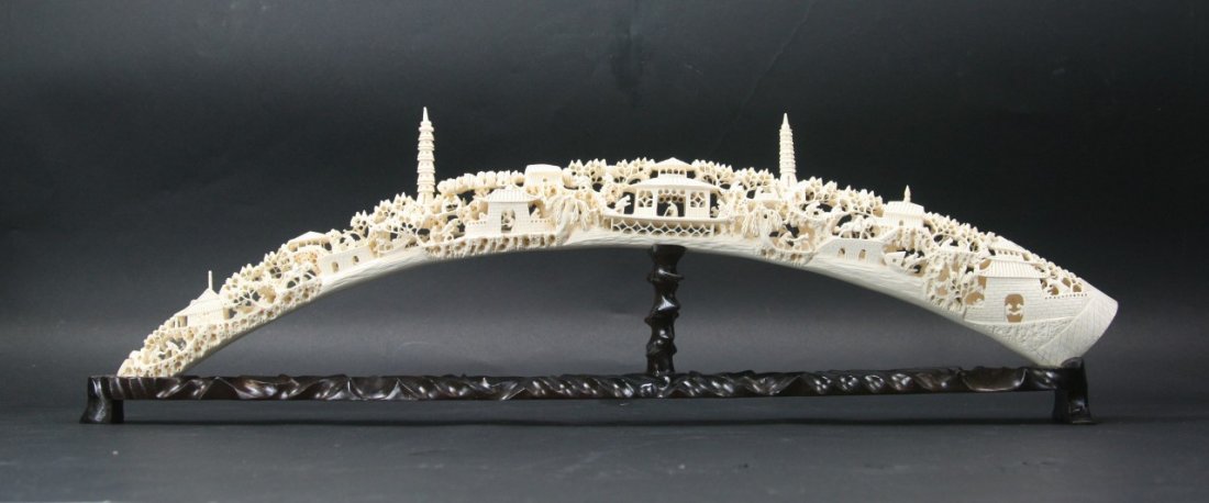 A Fine Chinese Ivory Bridge: A Chinese Ivory Bridge: elaborately fully pierced carved with typical landscape with towers, presented on fancy hardwood stand, of Minguo period; Size: L: 30-1/2"