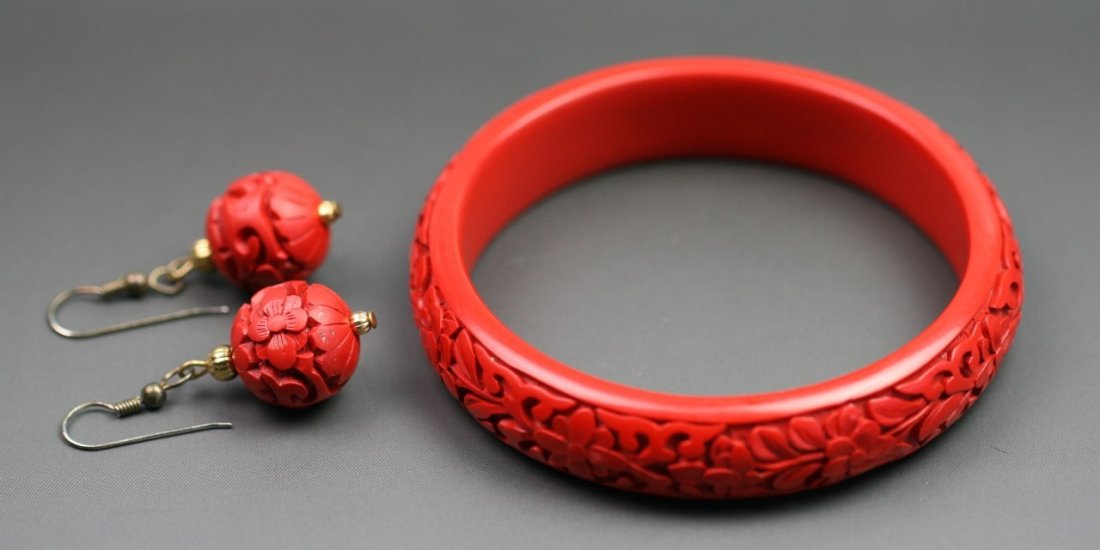 Set of Red Cinnabar Lacquer Earrings And Bangle: Set of Red Cinnabar Lacquer Earrings And Bangle: including a pair of earrings and a bangle, all finely carved with lotus flowers in deep, bangle measuring approximately 82. 6mm in diameter and 15. 3mm