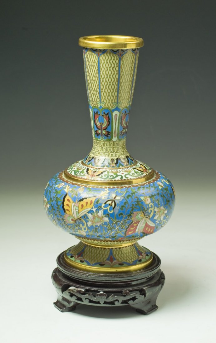 A Chinese Antique Cloisonne Bronze Vase With Stand: A Chinese Antique Cloisonne Bronze Vase With Stand: finely painted around the compressed globular body and long neck with butterflies amid leafy stems, presented on wood stand, of Minguo period; Size: