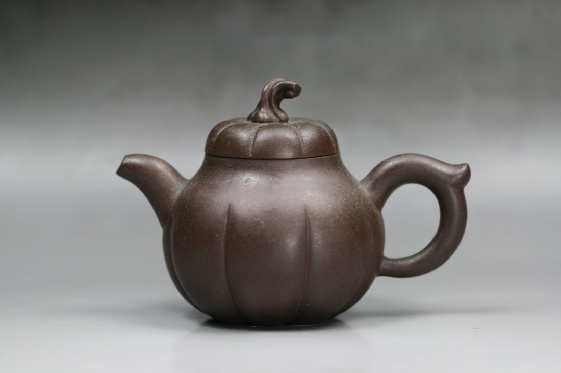 A Fine Yixing Purple Clay Zisha Teapot: A Fine Yixing Purple Clay Zisha Teapot: well potted of pumpkin form with short handle and stout on the opposite, the fitted rounded cover with stem shaped finial on top, sealed by the artist, the pott