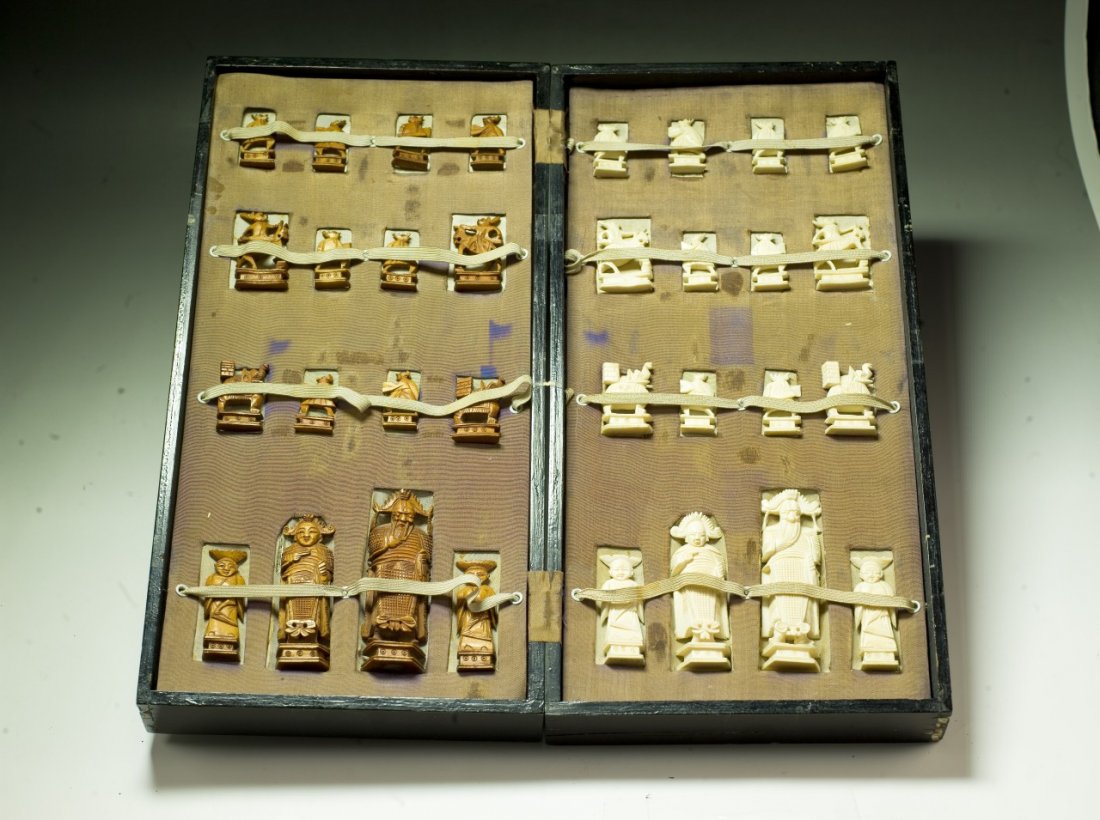A Complete Set of Chinese Carved Ivory Chess: A Complete Set of Chinese Carved Ivory Chess: all pieces present, the opposing sides of white ivory and sienna dyed ivory are all solid carved pieces all raised on plinths, very good condition, in woo