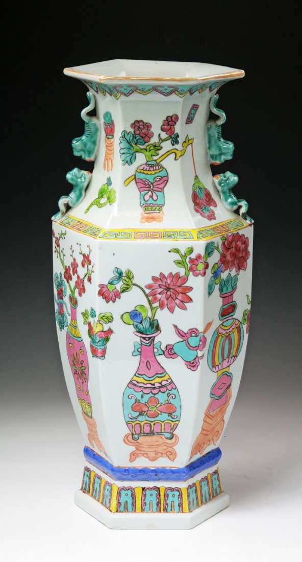 A Massive Chinese Antique Famille Rose Porcelain Vase: A Massive Chinese Antique Famille Rose Porcelain Vase: of hexagon form, well painted around the body with vases with blossoms, Chi dragon shaped handles on the shoulders, of Qing Dynasty; Size: H: 18"
