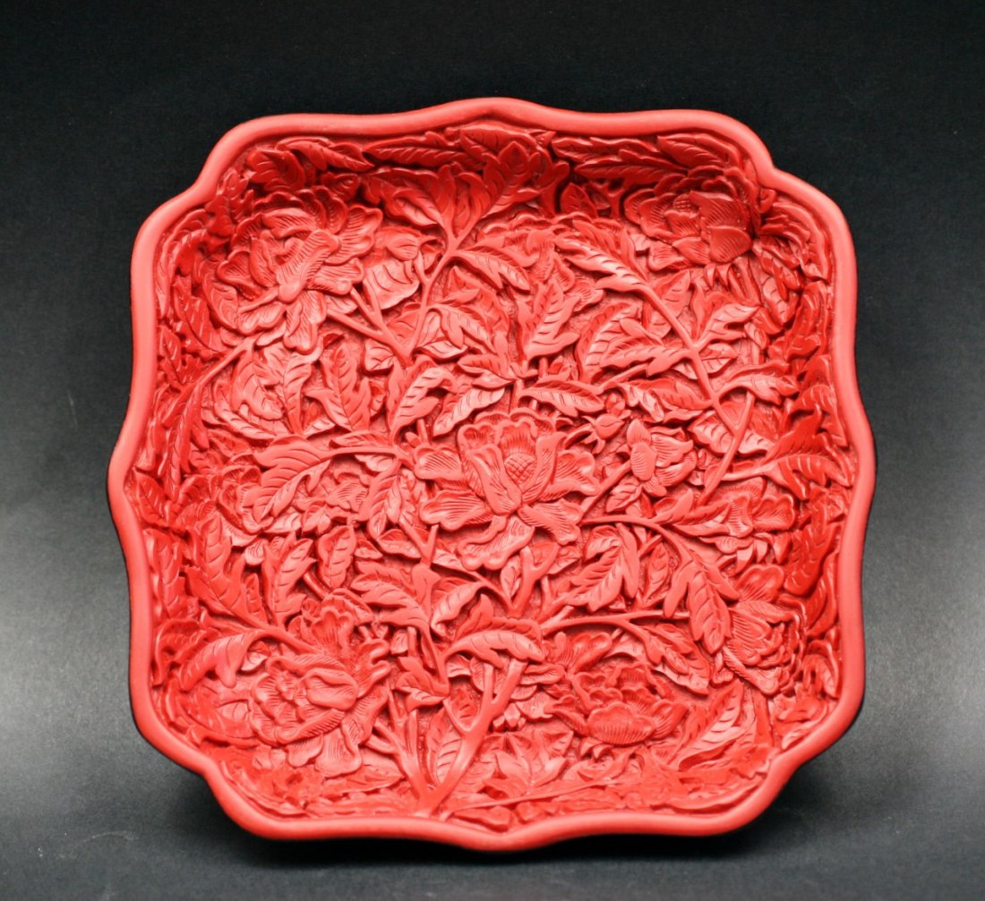A Chinese Antique Red Cinnabar Lacquer Plate: A Chinese Antique Red Cinnabar Lacquer Plate: of rounded square form, finely carved through multiple layers of cinnabar lacquer with blossoms amid leafy stems, of Qing Dynasty; Size: L: 5-1/2"
