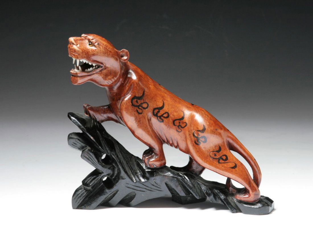 A Japanese Antique Wood Tiger: A Japanese Antique Wood Tiger: presented on a wood stand; early 20th Century; Size: L: 8"; H: 7"