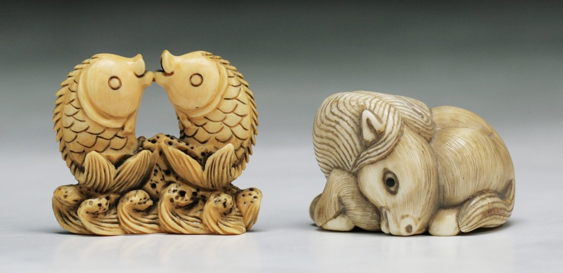 Two Carved Antique Ivory Netsuke: 象牙動物根付 兩件 Two Carved Antique Ivory Netsuke: finely carved and rare, two fish jumping from cresting waves; a donkey rested on its legs, both 