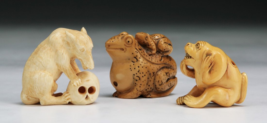 Three Carved Antique Ivory Netsuke: 象牙動物根付 三件 Three Carved Antique Ivory Netsuke: wolf, frogs and monkey, all with inlaid eyes, one signed on the base, all of 19th Century; Siz