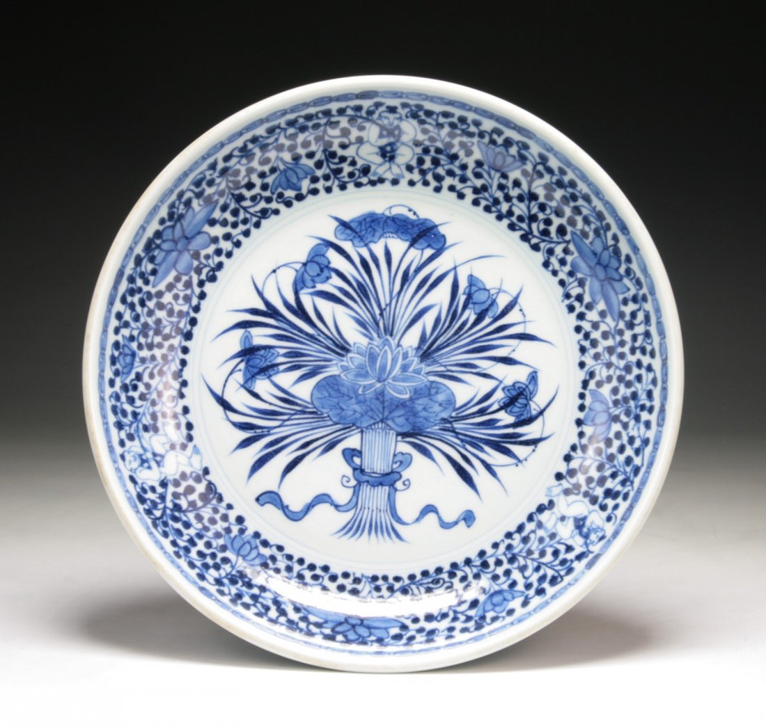 A Chinese Antique Qing Blue & White Porcelain Plate: A Chinese Antique Qing Blue & White Porcelain Plate: Chinese antique and beautifully painted, the center with design of lotus sprays on vines with band of lotus blossoms and meandering foliage to rim,