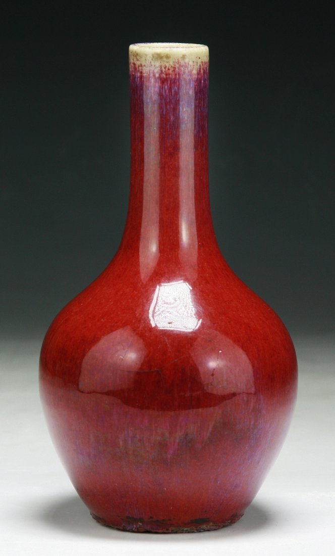 A Chinese Antique Ox-Blood Glazed Porcelain Vase: A Chinese Antique Ox-Blood Glazed Porcelain Vase: heavily potted with globular body with a cylindrical neck, applied overall with ox-blood red glaze, of late Qing Dynasty; Size: 7-1/2”