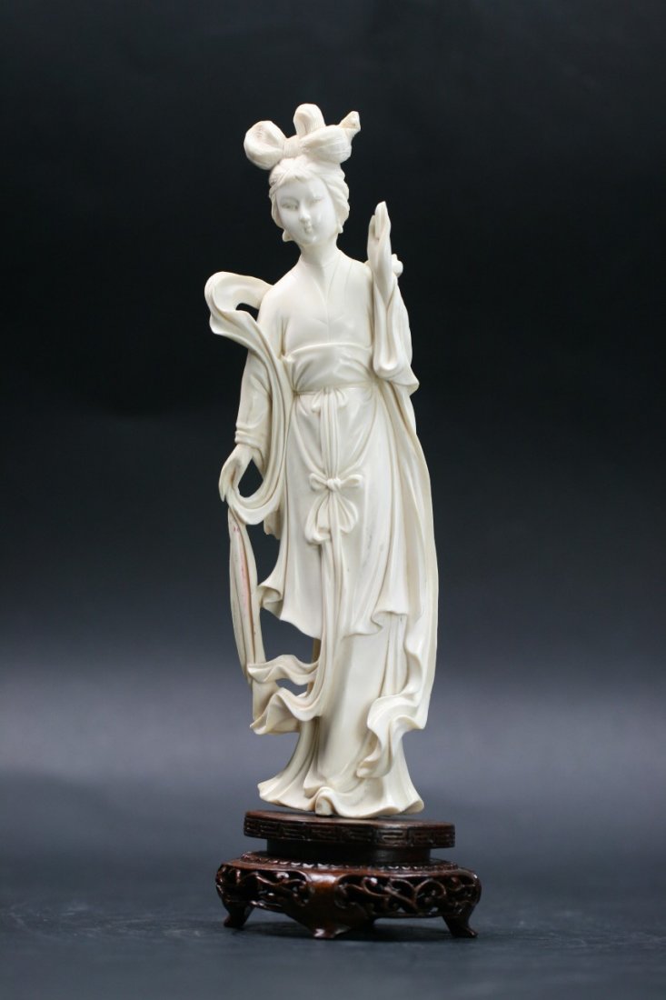 A Chinese Carved Ivory Beauty: A Chinese Carved Ivory Beauty: well carved as a beauty standing in flowing robes, mounted on wood stand; Size: H: 10"