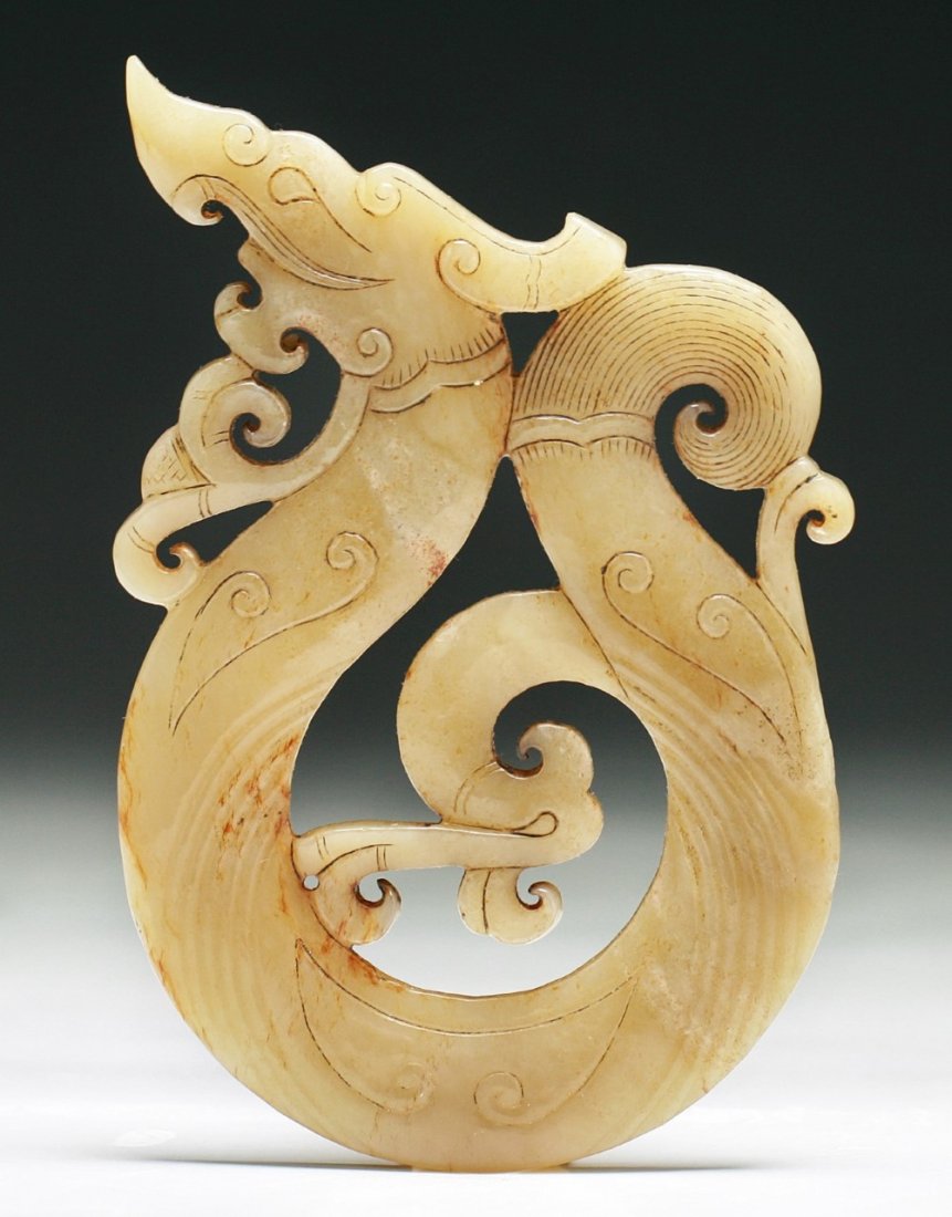 A Chinese Archaic Jade Pendant: A Chinese Archaic Jade Pendant: finely carved as an dragon in flight, the jade of yellowish grey color, of Warring Period; Size: H: 4-3/4"
