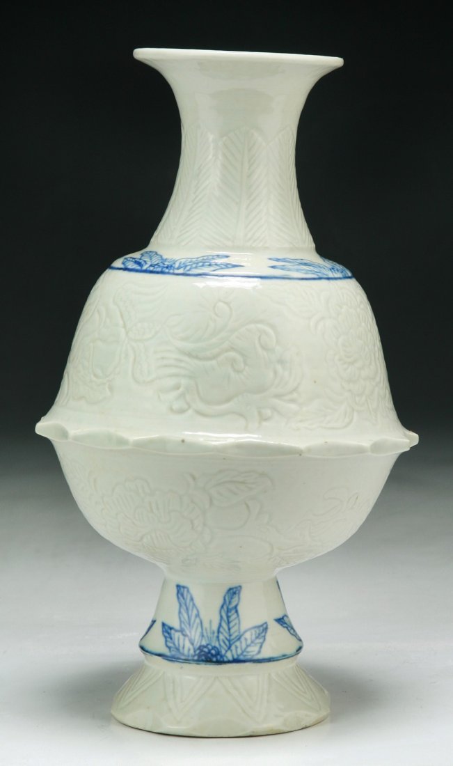 A Rare Chinese Antique Blue & White Porcelain Vase: A Rare Chinese Antique Blue & White Carved Porcelain Vase: very unusual, finely potted of baluster form with cylindrical neck to a flared rim, deftly carved with blossom and leaf sprays, painted aroun