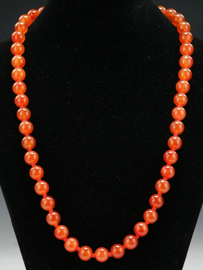 A Carnelian Agate Necklace: A Carnelian Agate Necklace: well carved and polished from the carnelian agate with warm red tone as beads measuring approximately 12mm each; Size: L: 24"; (bead) D: 12mm