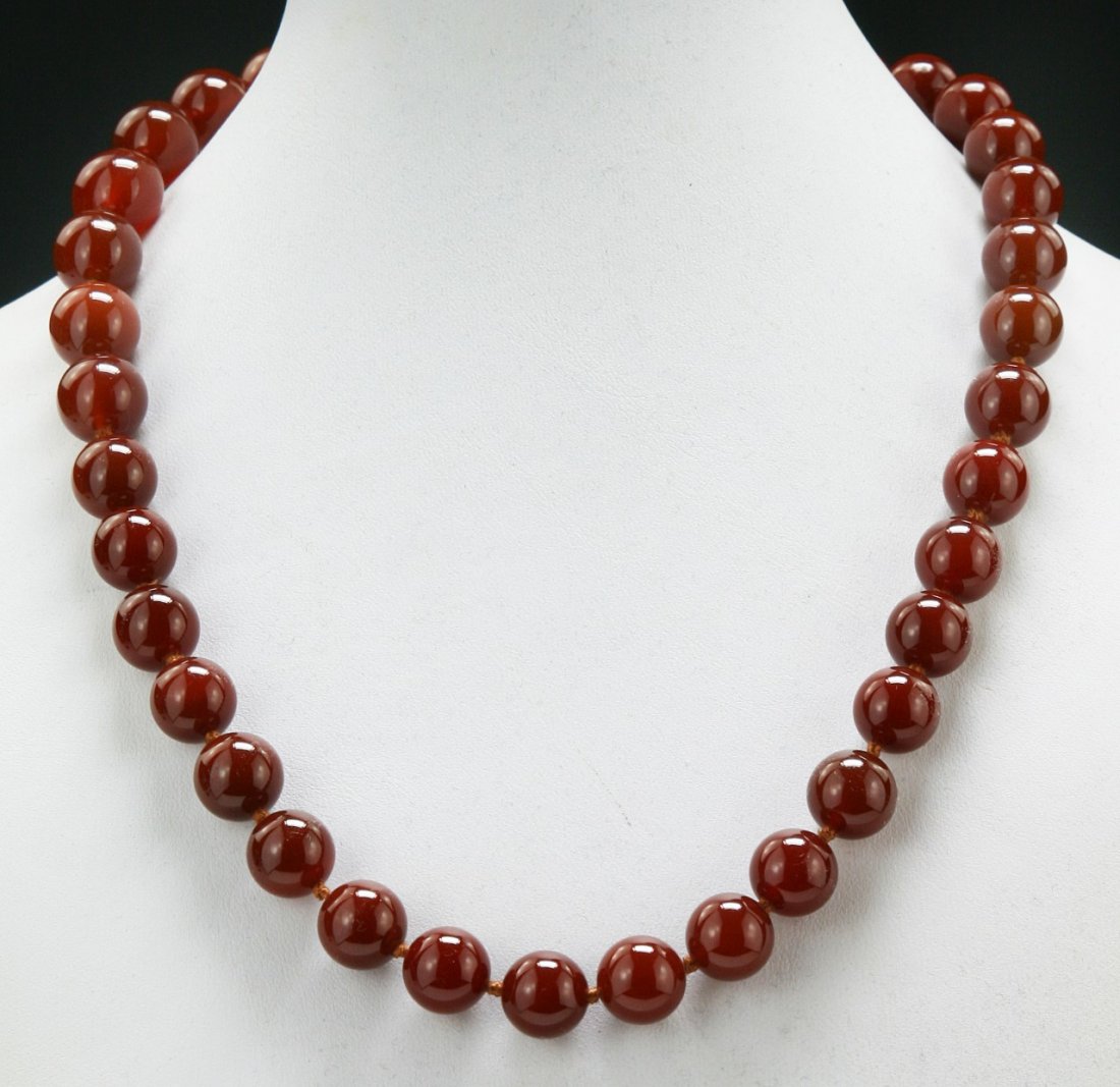 A Carnelian Agate Necklace: A Carnelian Agate Necklace: well carved and polished from the carnelian agate with warm red tone as beads measuring approximately 12mm each; Size: L: 18"; (bead) D: 12mm
