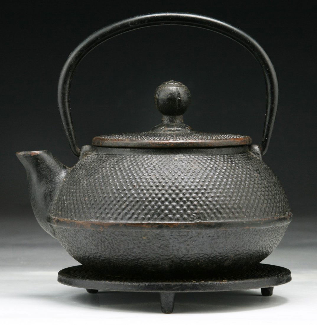 A Japanese Antique Iron Teapot: A Japanese Antique Iron Teapot: presented on a stand; Size: H: 7"