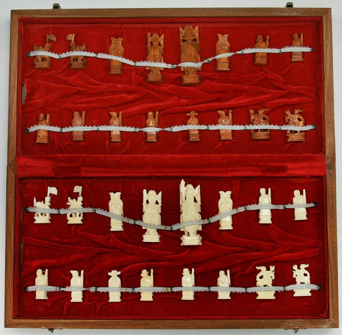 A Complete Set Of Chinese Carved Ivory Chess: A Complete Set Of Chinese Carved Ivory Chess: all pieces present, the opposing sides of white ivory and sienna dyed ivory are all solid carved pieces all raised on plinths, very good condition, in woo