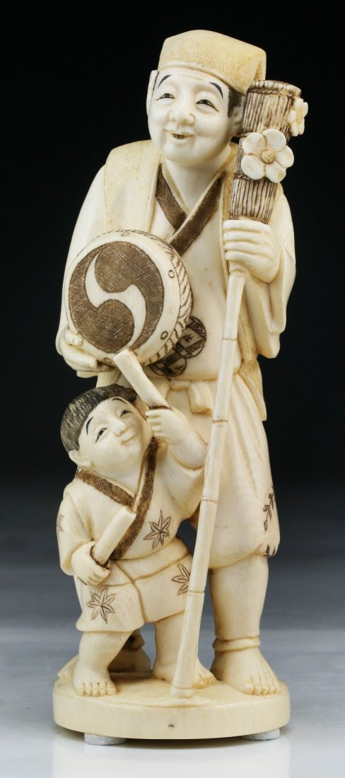A Japanese Antique Ivory Carved Figure Group: A Japanese Antique Ivory Carved Figure Group: detailed as a man and child standing beside him; Size: H: 7-1/4"