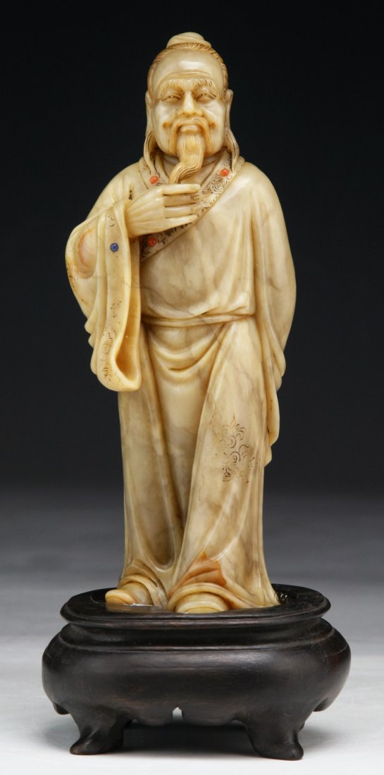 A Chinese Antique Jeweled Shoushan Soapstone Figure: A Chinese Antique Jeweled Shoushan Soapstone Figure: inlaid with lapis lazuli and carnelian agate beads, probably of Qing Dynasty, presented on a wood stand; Size: H: 5-3/4"; (overall) H: 7"