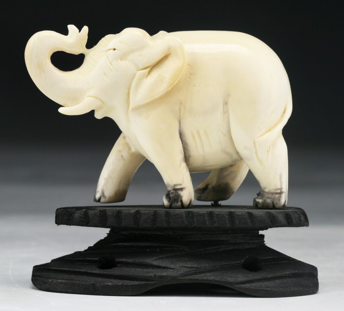 A Chinese Antique Carved Ivory Elephant: A Chinese Antique Carved Ivory Elephant: presented on a wood stand; Size: L: 2-3/4" (overall)