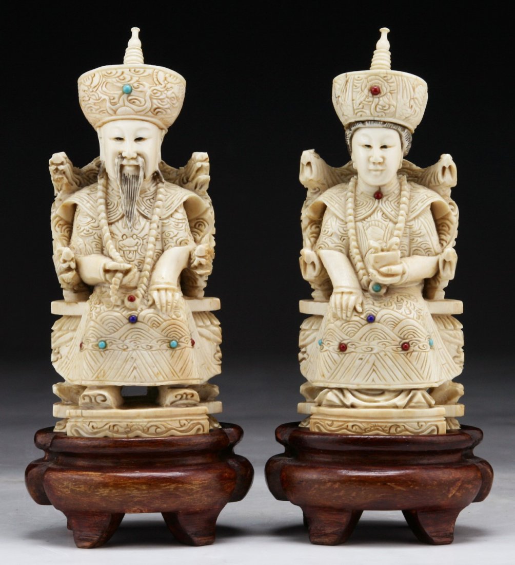 A Pair Of Chinese Antique Jeweled Ivory Emperor &: A Pair Of Chinese Antique Jeweled Ivory Emperor & Empress: each carved as a seated figure, dressed in court tones decorated with coral, turquoise and carnelian agate beads, both with wood bases; Size: