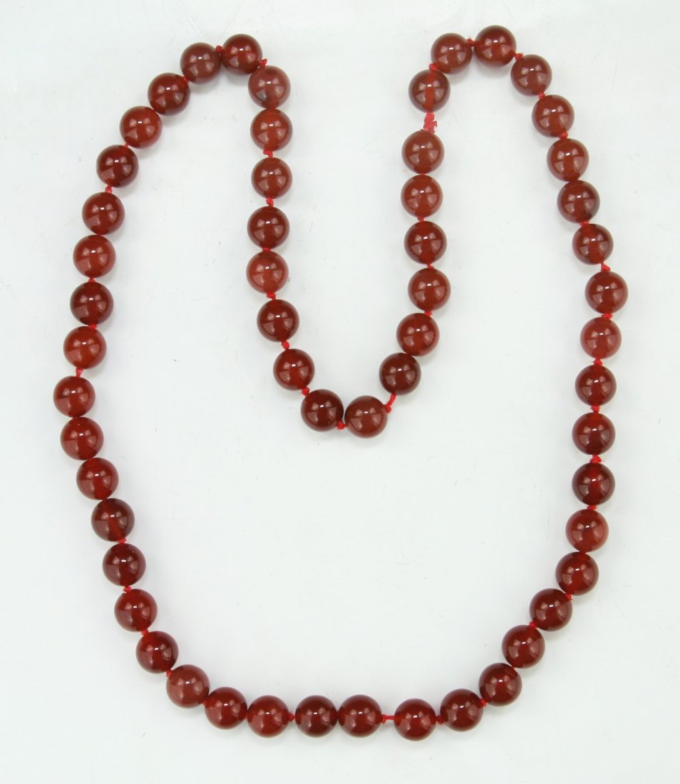 A Chinese Antique Carved Carnelian Agate Bead Necklace: A Chinese Antique Carved Carnelian Agate Bead Necklace: comprised of circular beads with the diameter of approximately 10mm each; Size: L: 25"; (bead) D: 10mm