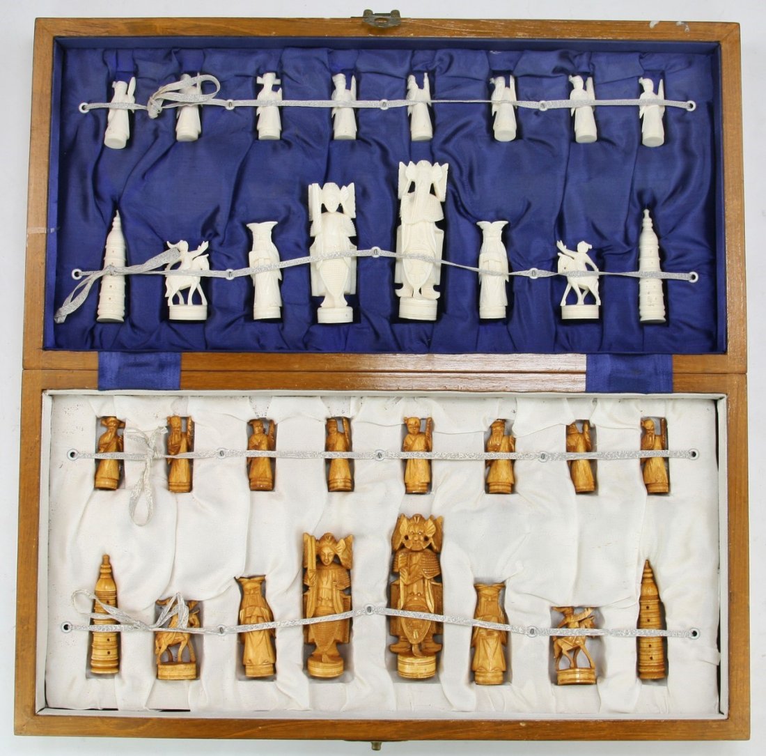 A Chinese Antique Carved Ivory Chess Set: A Chinese Antique Carved Ivory Chess Set: all pieces present, the opposing sides of white ivory and sienna dyed ivory are all solid carved pieces all raised on plinths, African ivory, Late Qing Dynast