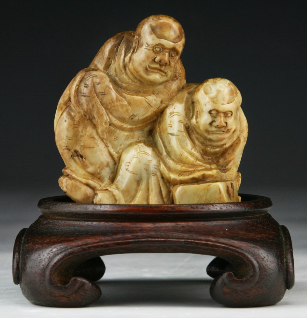 A Chinese Soapstone Carved Figure: A Chinese Soapstone Carved Figure: presented on a wood stand; Size: H: 3-3/4" (overall)