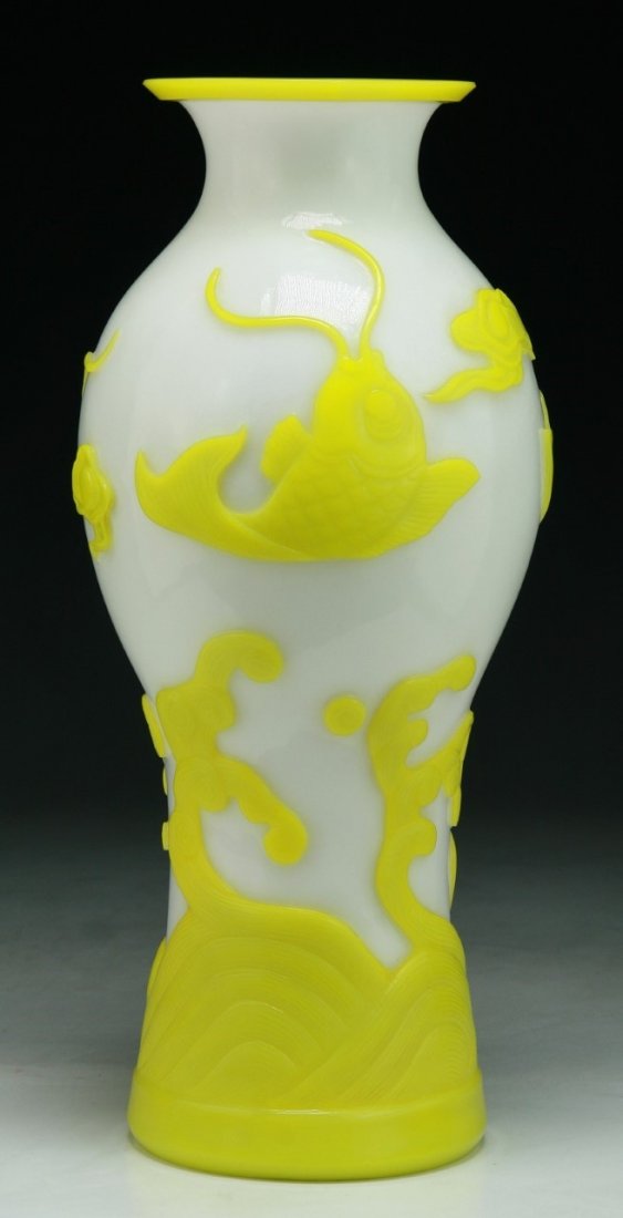A Chinese Antique Carved Overlay Peking Glass Vase: A Chinese Antique Carved Overlay Peking Glass Vase: skillfully carved through the yellow Peking glass to the milky white ground with the scene of fish jumping over cresting waves; Size: H: 12-3/4"
