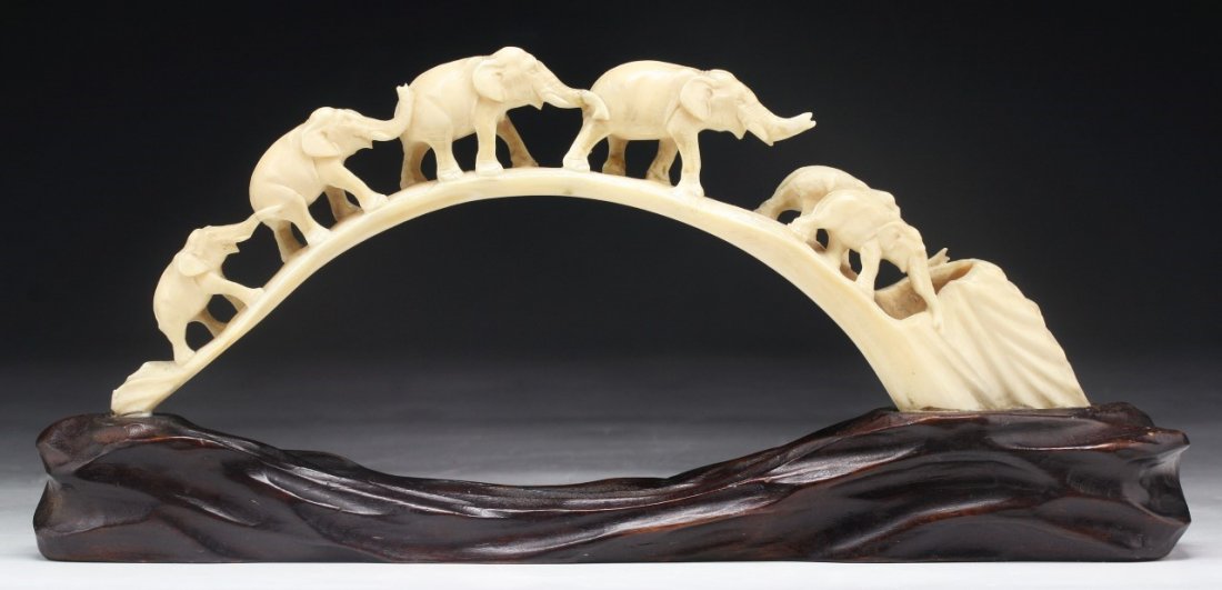 A Chinese Antique Carved Boar Ivory Tusk: A Chinese Antique Carved Boar Ivory Tusk: carved as five elephants walking in a line, presented on a matching wood stand, African ivory, circa 1900, NO INTERNATIONAL SHIPPING OF IVORY ITEMS; Size: L: 
