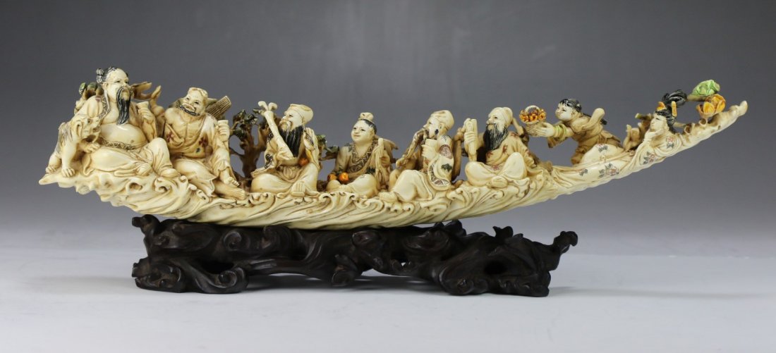 A Chinese Antique Ivory Carved Tusk: A Chinese Antique Ivory Carved Tusk: elaborately carved as the eight immortals sitting side by side along the tusk, presented on a wood stand, African ivory, of late Qing Dynasty (19th Century), NO IN
