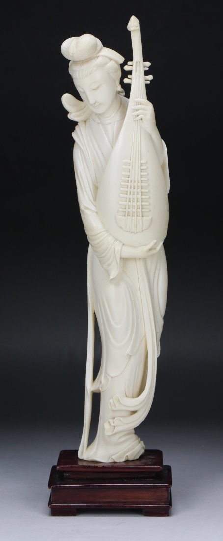 A Chinese Antique Ivory Carved Beauty: A Chinese Antique Ivory Carved Beauty: finely carved as a beauty in long flowing robes holding a large guitar with both hands, presented on a wood stand, African ivory, circa 1900; Size: H: 13-1/2”;