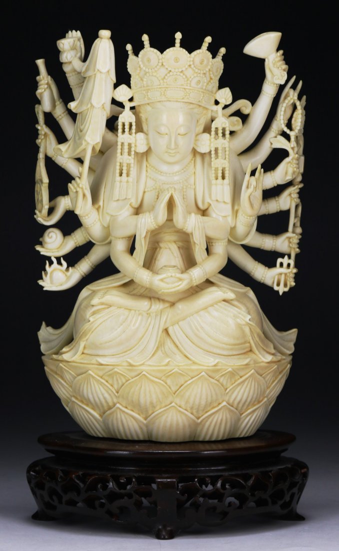 A Chinese Antique Ivory Carved Guanyin: A Chinese Antique Ivory Carved Guanyin: finely carved as Guanyin with multiple arms in a seated position atop a lotus plinth, presented on a wood stand, African ivory, Late Qing Dynasty (19th Century)