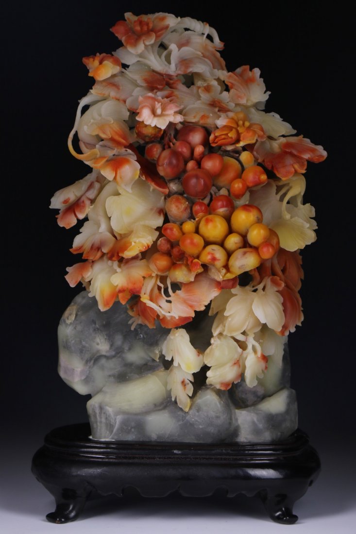 A Soapstone Carved Group: A Soapstone Carved Group: presented on a wood stand; Size: H: 9-1/2"; (overall) H: 11-1/4"