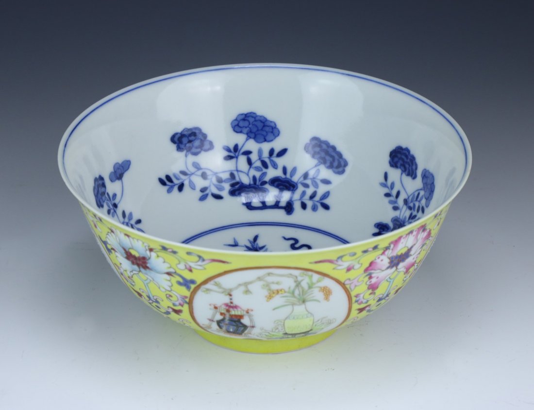 A Chinese Antique Famille Rose Porcelain Bowl: A Chinese Antique Famille Rose Porcelain Bowl: the exterior finely painted with medallions of scholar objects and blossoming flowers on a royal yellow glazed ground, the interior with a blue floral mo