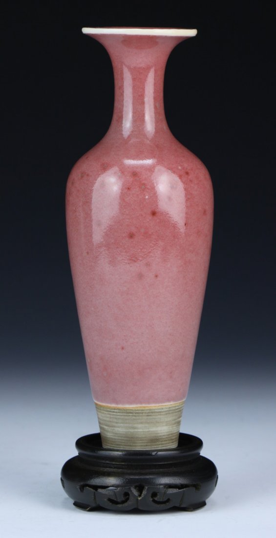 A Chinese Antique Peach Bloom Glazed Porcelain Vase: 清豇豆紅柳葉瓶 A Chinese Antique Peach Bloom Glazed Porcelain Vase: presented on a wood stand, of Mid-Qing Dynasty; Size: H: 7-1/4" (with stand); H: 6-1/2"