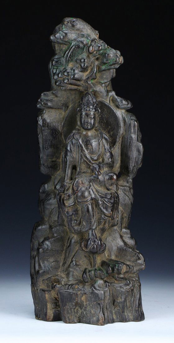 A Chinese Antique Wood Carved Guanyin: A Chinese Antique Wood Carved Guanyin: finely carved as Guanyin with high headdress seated on rockery with her foot resting on a lotus; Size: H: 11-3/4"