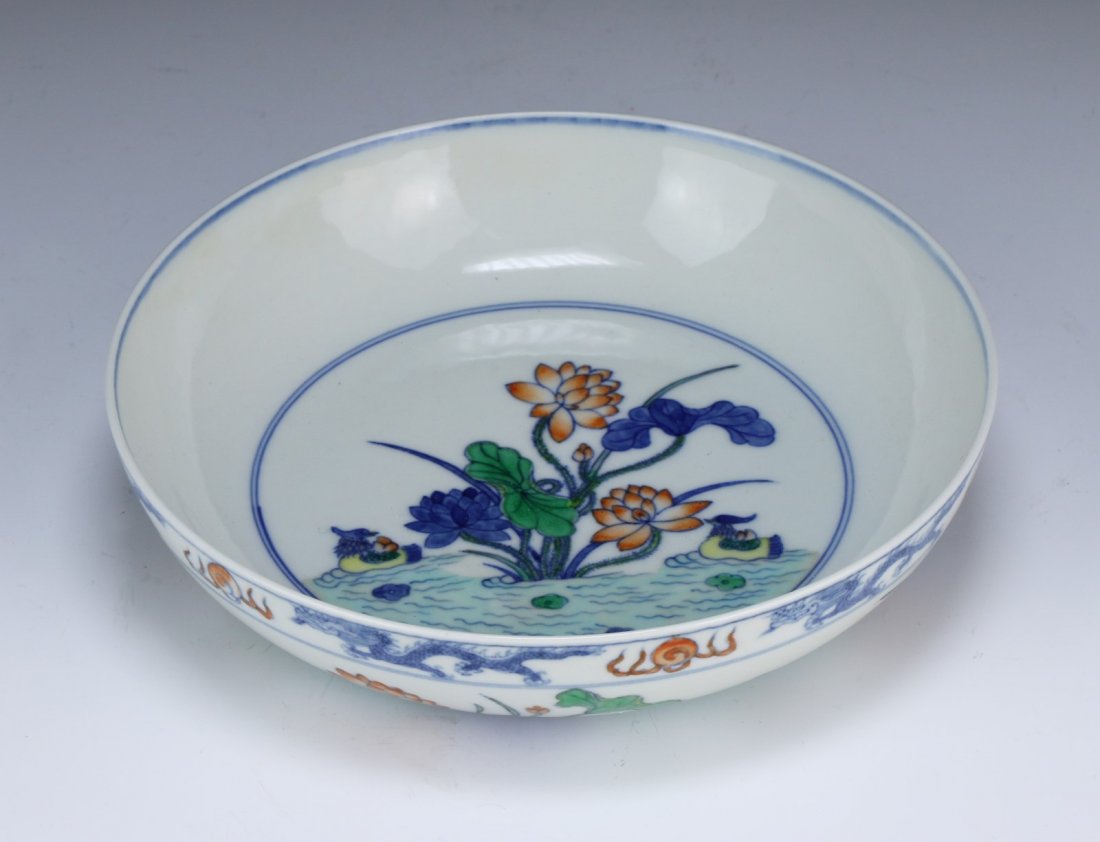 A Chinese Antique DOUCAI Porcelain Bowl: A Chinese Antique DOUCAI Porcelain Bowl: the exterior finely painted with lotus and birds in water, the rim with dragons chasing flaming pearls, the interior with the same design, the base with a six