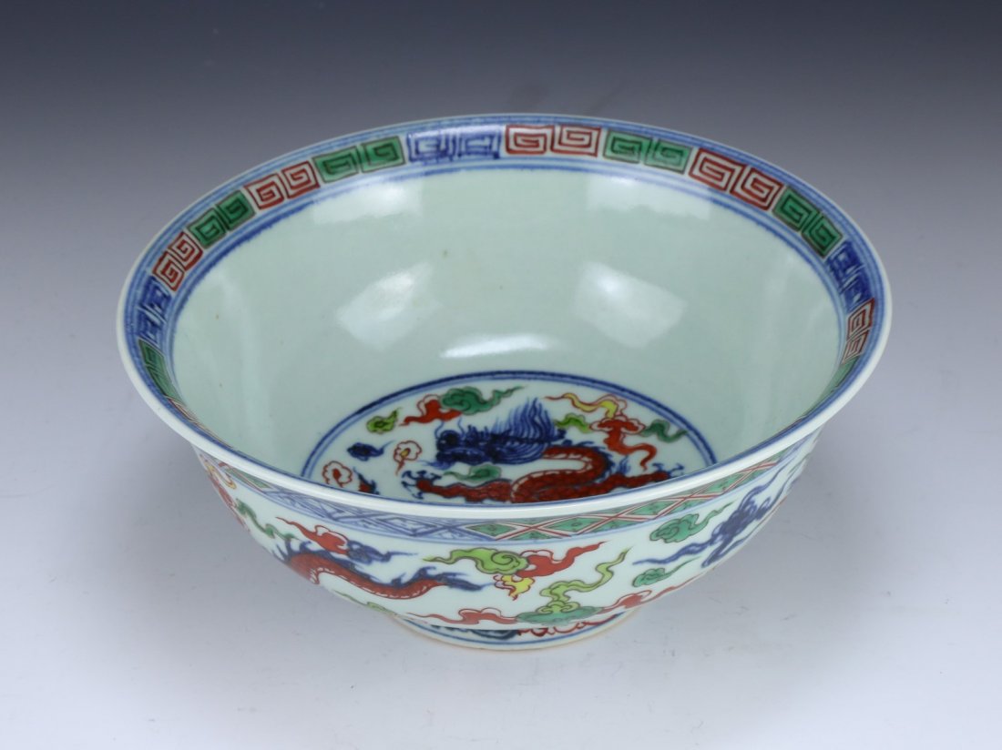 A Fine WUCAI 'Dragon And Phoenix' Bowl: A Fine WUCAI 'Dragon And Phoenix' Bowl: XUANDE SEAL MARK IN UNDERGLAZE BLUE, with deep rounded sides rising to a slightly everted rim, the exterior painted with phoenix descending between green and ir