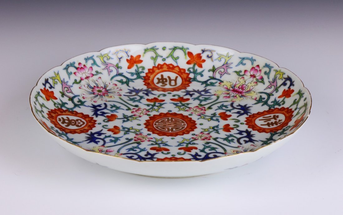 A Chinese Antique Famille Rose Porcelain Plate: A Chinese Antique Famille Rose Porcelain Plate: the interior finely painted with medallions and scrolling blossoms, the base with a QIANLONG mark in cobalt blue; Size: D: 9"