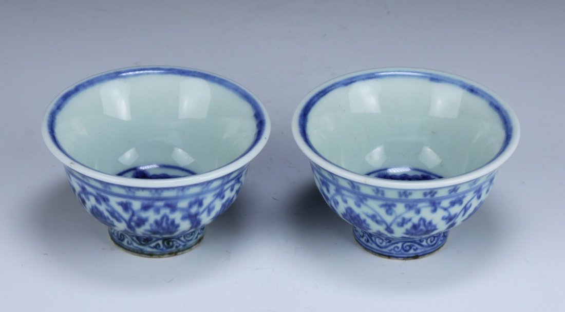 A Chinese Antique Pair of Blue & White Cups: featuring a small base that extends upwards into a flared rim, finely painted with blooming flowers and their stems; Size: D: 3-1/2" (8. 89cm) [Each]