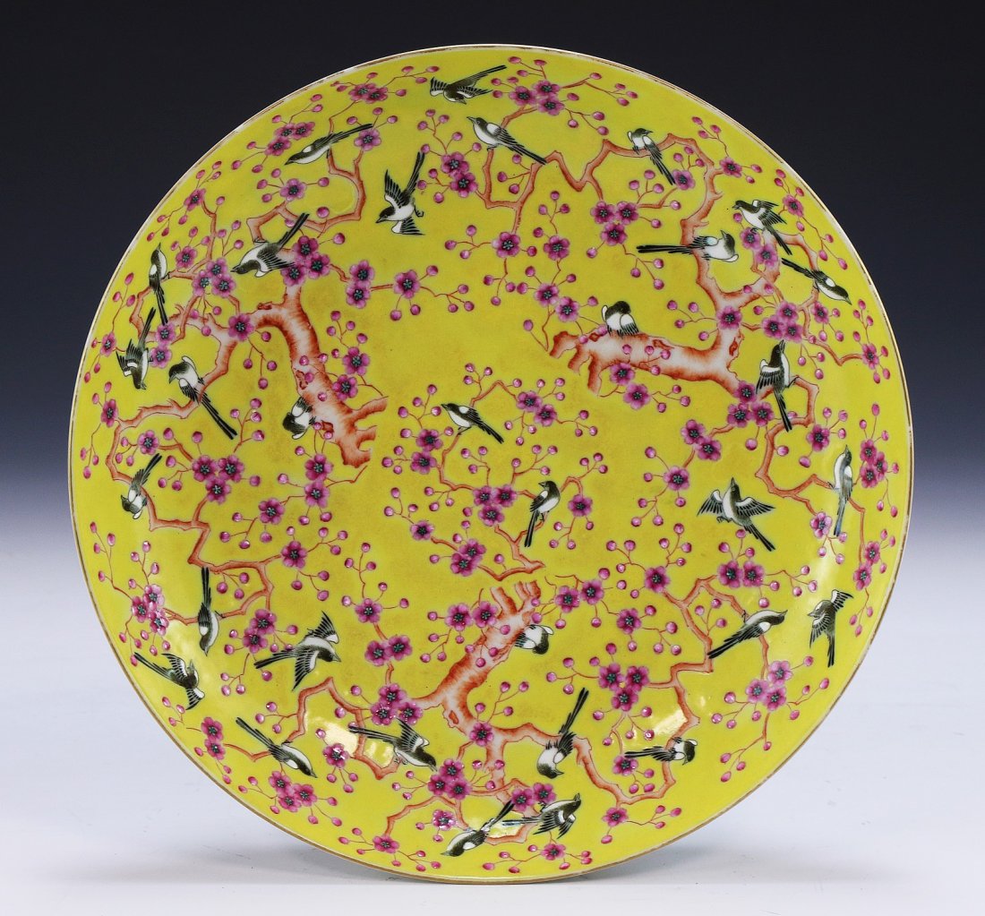 A Chinese Antique Famille Rose Porcelain Plate: A Chinese Antique Famille Rose Porcelain Plate: the interior finely painted with blossoming branches and black birds on a yellow glazed ground, the back with scrolling blossoms and a six character mar
