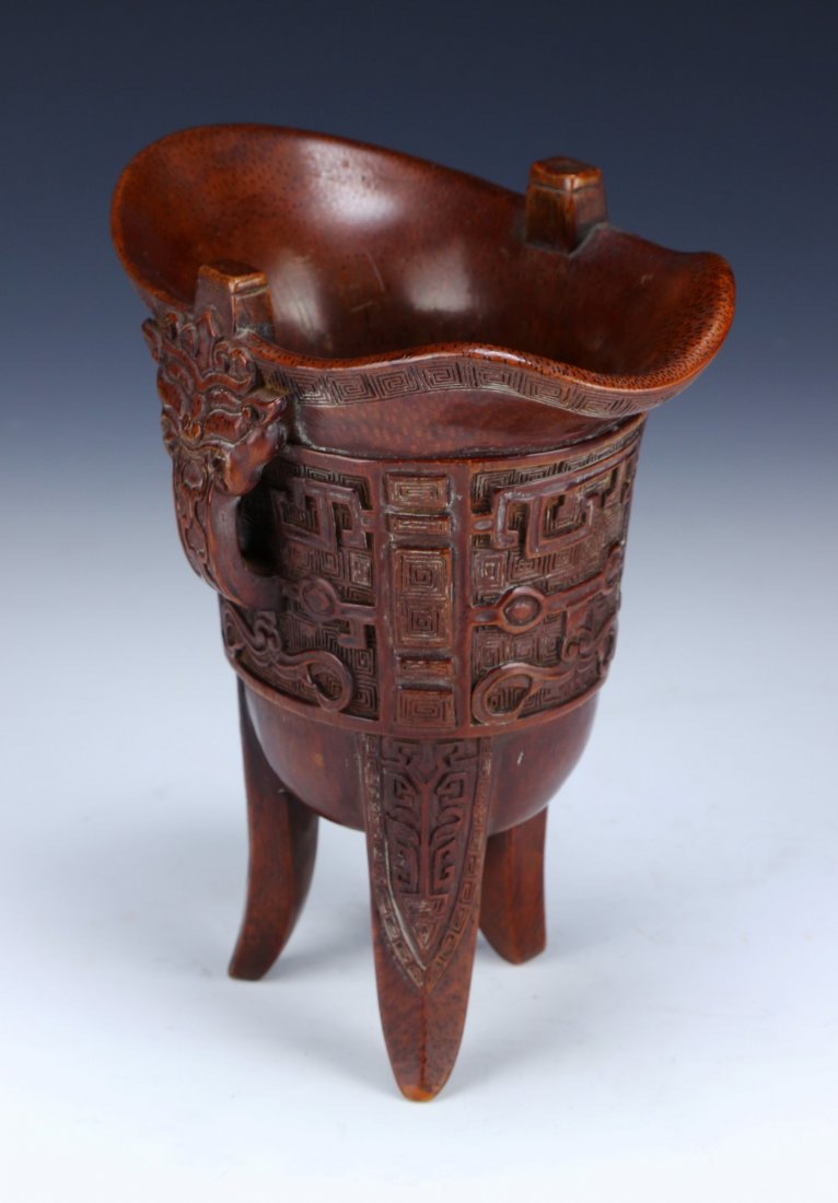 A Chinese Antique Bamboo Ritual Tripod Wine Vessel, Jue: 清 竹根雕獸面紋爵杯A Chinese Antique Bamboo Ritual Tripod Wine Vessel, Jue: Raised On Three Blade-Shaped Supports, The Deep Body Is Carved in Reli