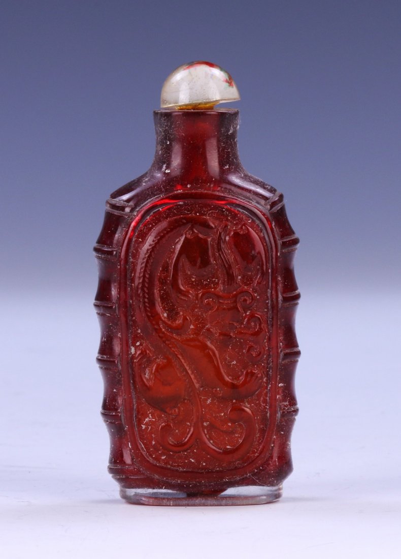 A CHINESE ANTIQUE PEKING GLASS SNUFF BOTTLE: A Chinese Antique Peking Glass Snuff Bottle: Of Rectangular Form, Each Side Of The Body Finely Carved With A Qilin Dragon Figure Set in High Relief; Size: H: 3" (7.62cm)